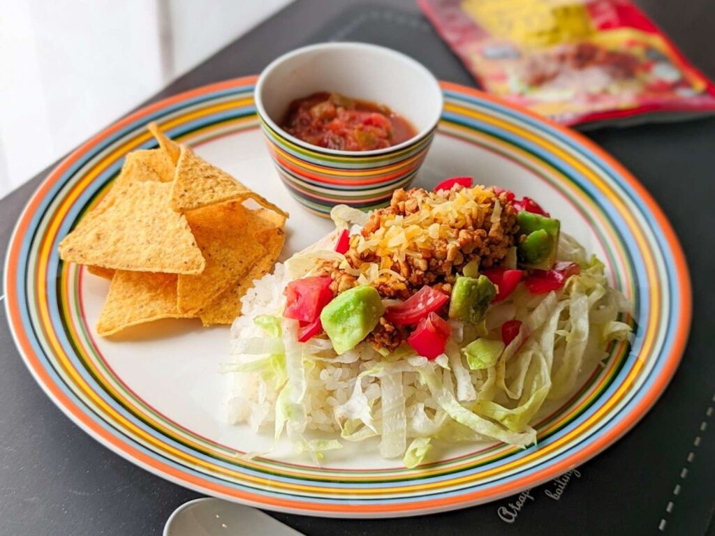 お皿にのったタコライスとトルティーヤチップス。サルサがそえられている。