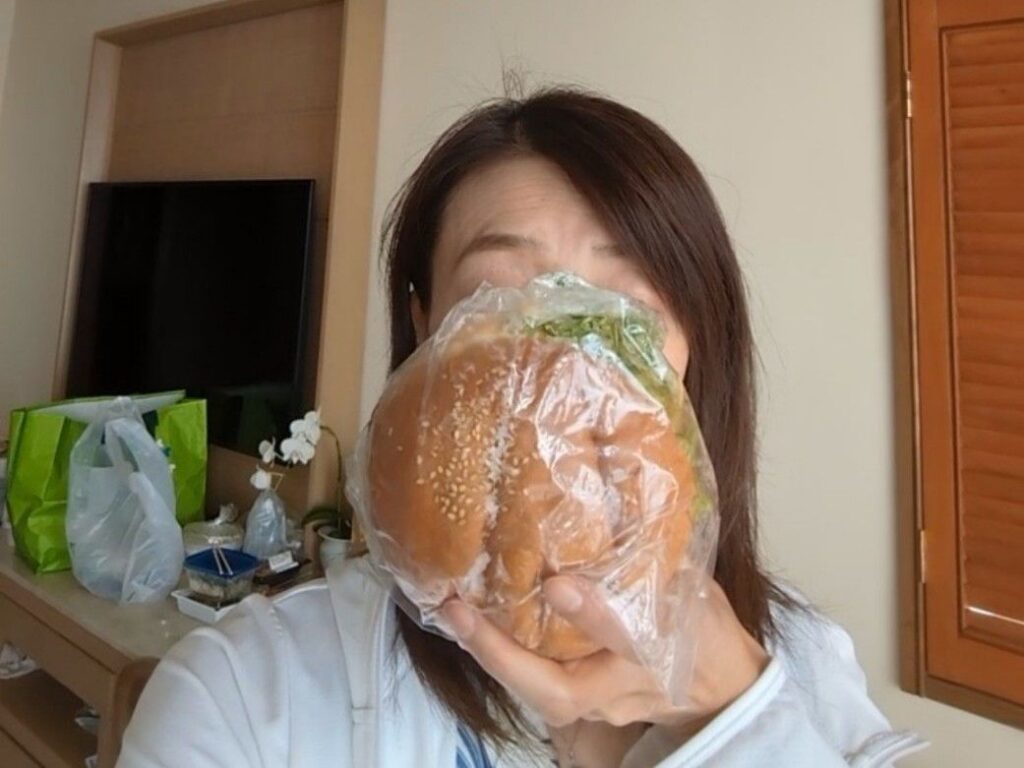 キングタコスのタコバーガーを顔の前に置き大きさを比較した画像